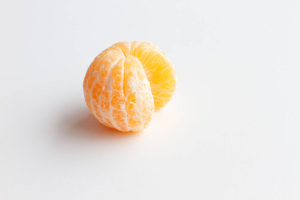 Mandarin isolated on white background. One peeled tangerine and a slice of Mandarin. - Zdjęcie, obraz