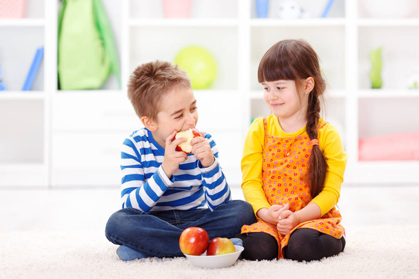Funny little boy eating apple - Foto, immagini