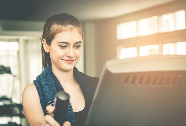 Kadın egzersiz makinesi ekran ile mutlu yüz arıyor - Fotoğraf, Görsel