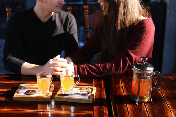 Pareja sentada cerca de la mesa con caldo de espino cerval de mar en café discu
 - Foto, Imagen