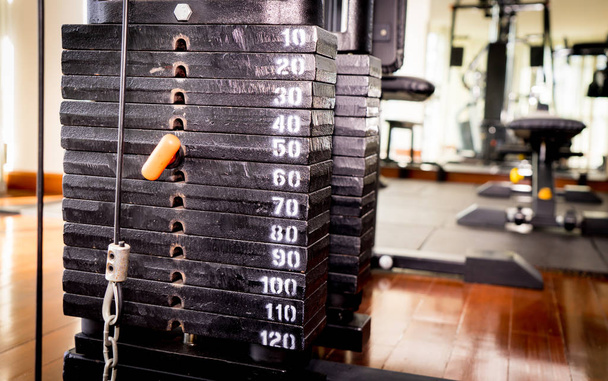 Металева вага стоїть на тренувальній машині для фітнесу
 - Фото, зображення