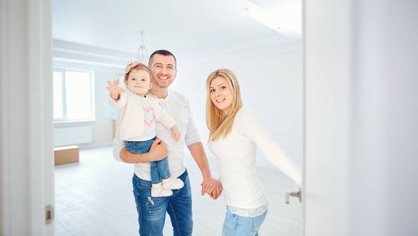 A happy family opens the door to their apartment. - Valokuva, kuva