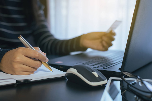 Закрытие руки женщины с кредитной картой и запись данных для онлайн-покупки концепции
 - Фото, изображение
