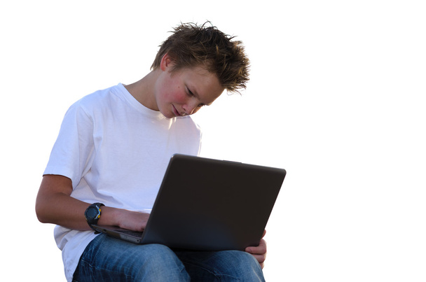 Tiener met stekelige haren werk op laptop (geïsoleerd op wit) - Foto, afbeelding