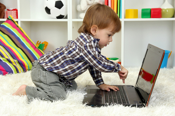 cute little boy and notebook in room - Foto, afbeelding