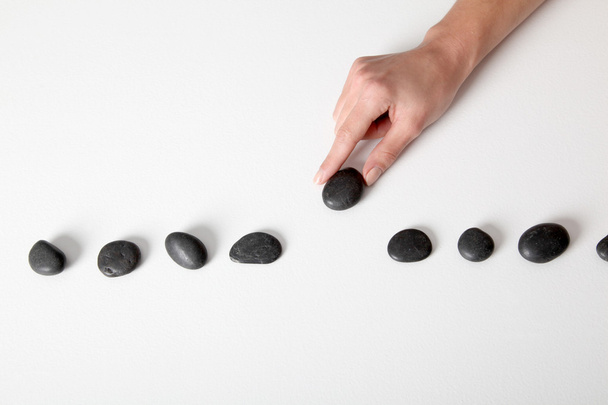 Human hand arranging line of pebbles - Фото, зображення