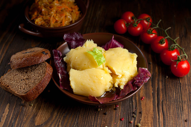 mashed potatoes, bread, greens and cherry tomatoes on a dark wooden table - Photo, Image
