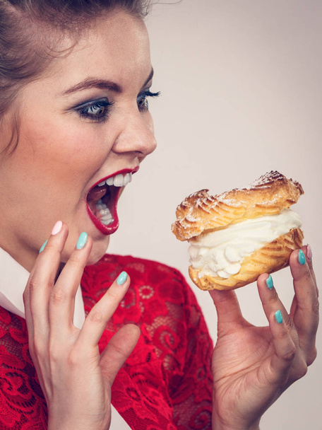 Funny woman holds cream puff cake - Zdjęcie, obraz