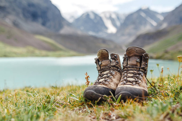 Hiker buty stojący na trawie w pobliżu jeziora w górach Ałtaj - Zdjęcie, obraz