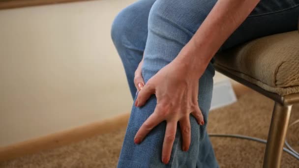 Mujer masajea su pierna dolorida o lesionada en su casa
 - Imágenes, Vídeo