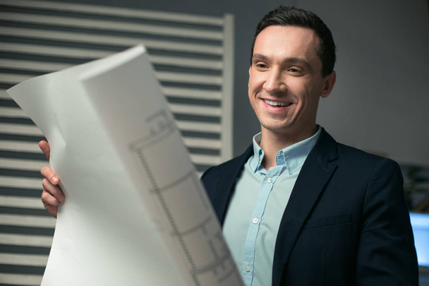 Pleased male architect satisfied with blueprint - Photo, image