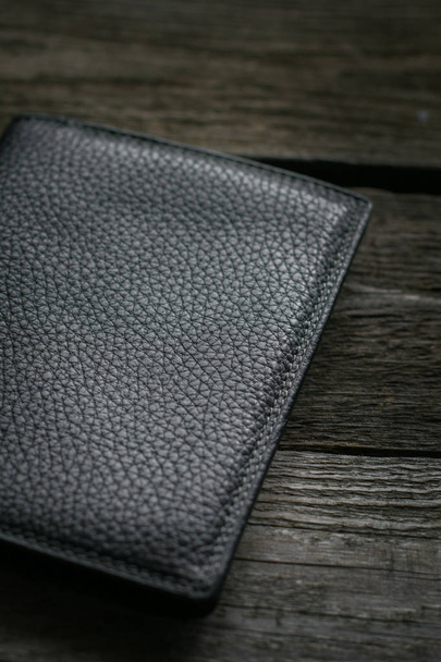 Black wallet on wooden board. - Фото, зображення