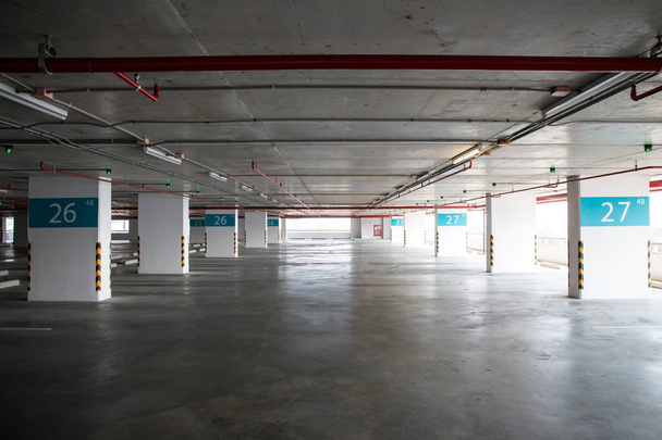 Empty space car park interior at afternoon.Indoor parking lot.interior of parking garage with car and vacant parking lot in parking building.some carpark empty in Condominium or department store. - Photo, Image