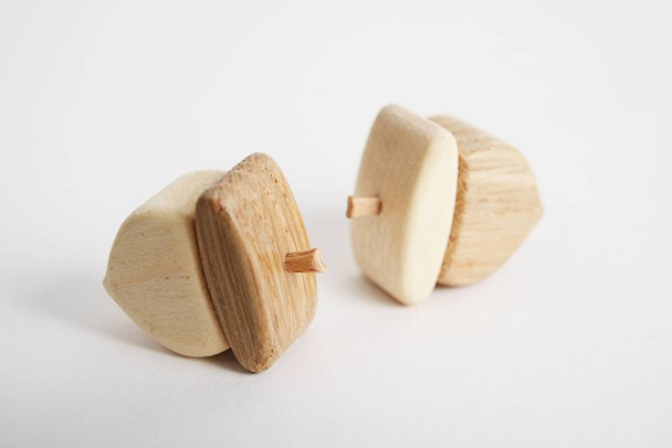 Wooden hand-made acorn toy for children isolated on the white background with shadow reflection. Wooden acorn for playing with kids. Natural typical wooden toy in the shape of cute acorn - Valokuva, kuva