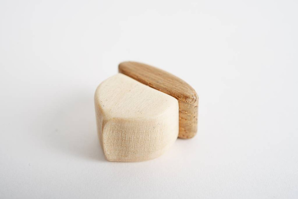 Wooden hand-made acorn toy for children isolated on the white background with shadow reflection. Wooden acorn for playing with kids. Natural typical wooden toy in the shape of cute acorn - Valokuva, kuva