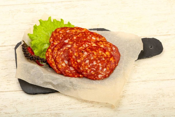 Sliced saborosa salsicha Chorizo sobre o fundo de madeira
 - Foto, Imagem