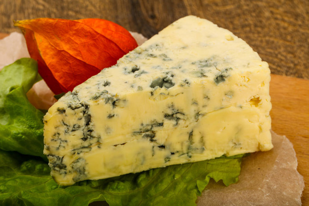Niebieski ser z liśćmi sałatki na drewnianym tle - Zdjęcie, obraz