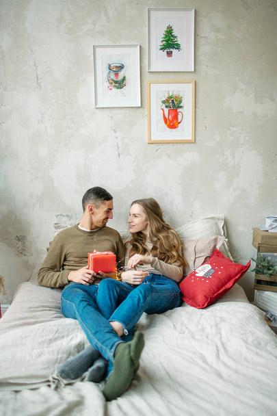 Young caucasian couple unboxing presents laying on bed - Фото, зображення