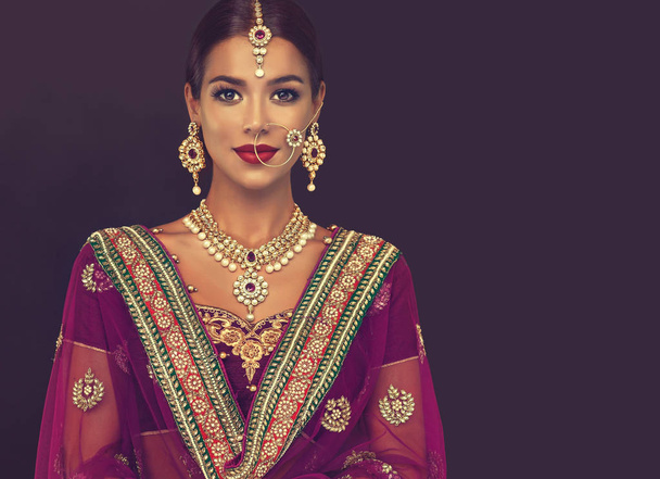 Портрет красивой индийской девушки. Молодая индуистка-модель с ювелирным набором кундан. Традиционные индийские костюмы lehenga choli или сари
 - Фото, изображение