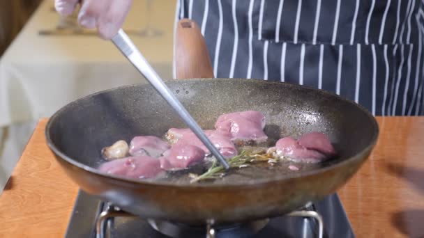 Close-up van chef-kok koken geflambeerd stijl schotel met plakjes lever op een hete koekenpan in restaurant. Slow motion. - Video