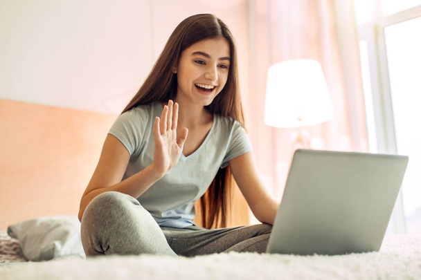 Cute teenage girl making a video call via laptop - Foto, immagini