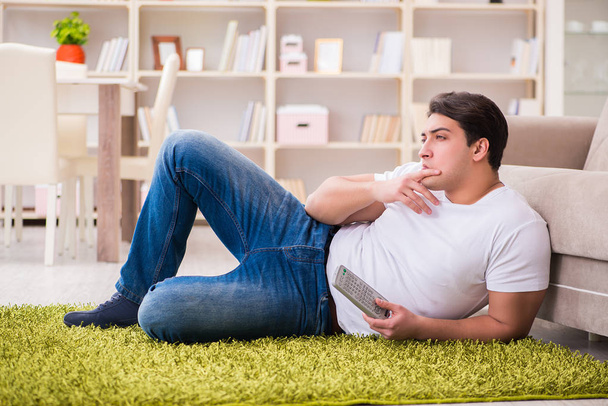 Hombre viendo la televisión en casa en el suelo - Foto, Imagen