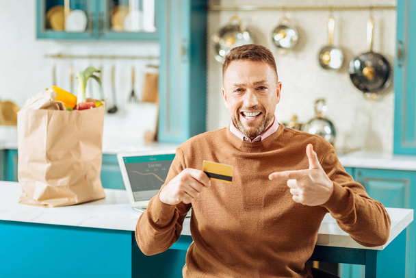 Happy nice man pointing at the credit card - 写真・画像