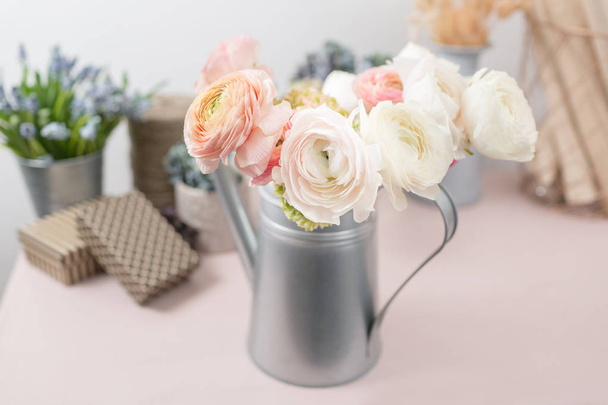 Buttercup persa. Ramo colorido ranúnculo flores fondo claro. Jarrón de metal sobre mesa de madera vintage rosa
. - Foto, imagen