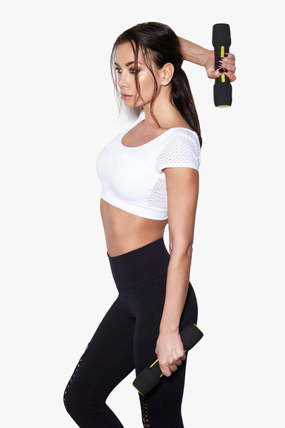 Sportieve vrouw doen haar workout met halters, geïsoleerd op witte achtergrond - Foto, afbeelding