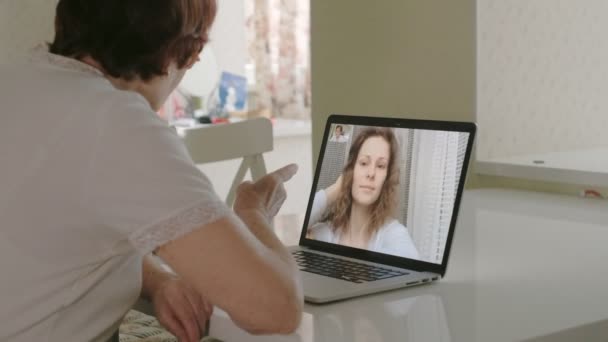 ηλικιωμένη γυναίκα Μιλήστε με την εγγονή της στο skype χρησιμοποιώντας ένα φορητό υπολογιστή - Πλάνα, βίντεο