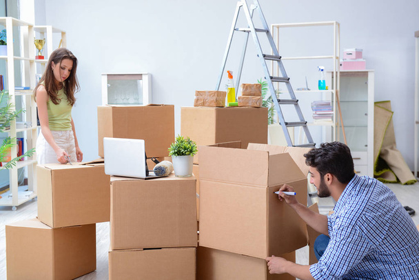 Young family unpacking at new house with boxes - 写真・画像