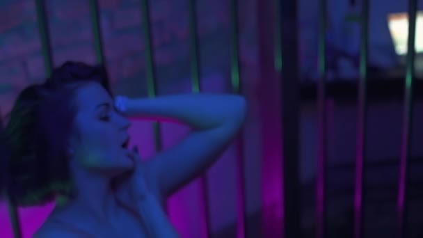 Hot young bob cut brunette girl in black lingerie seductive moves in metal cage - Metraje, vídeo