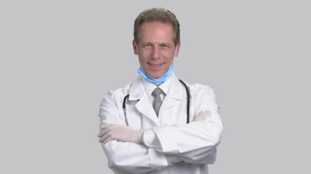 Mature doctor wearing medical gloves and folding arms. - Footage, Video
