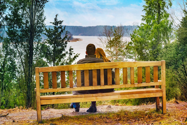 若い男がベンチに座っている女の子をハグ - 写真・画像