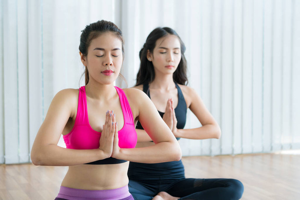 Mujeres practicando yoga posan en clase de gimnasia fitness
 - Foto, Imagen