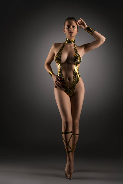 Well-shaped girl with gold tape body adornment - Photo, image