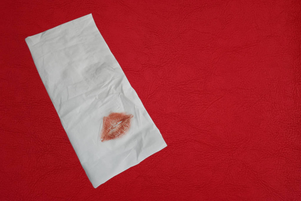Reddish brown lipstick on napkin white and top table surface. - Photo, Image