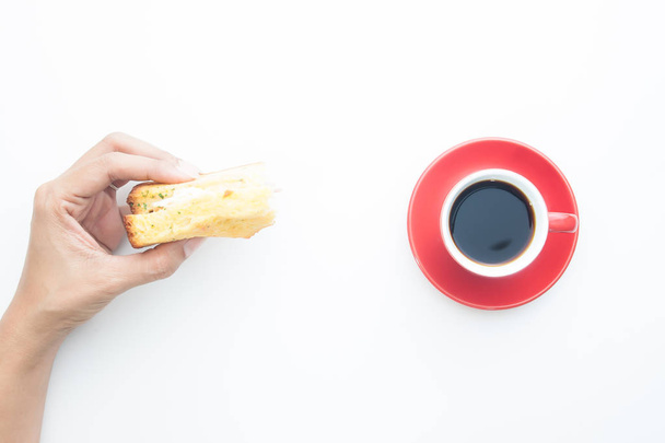 Directamente encima de la mano de la mujer sosteniendo sándwich con taza de café aislado sobre fondo blanco
 - Foto, imagen