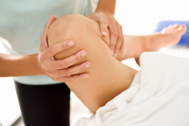 Medische massage aan het been in een fysiotherapeutisch centrum. - Foto, afbeelding