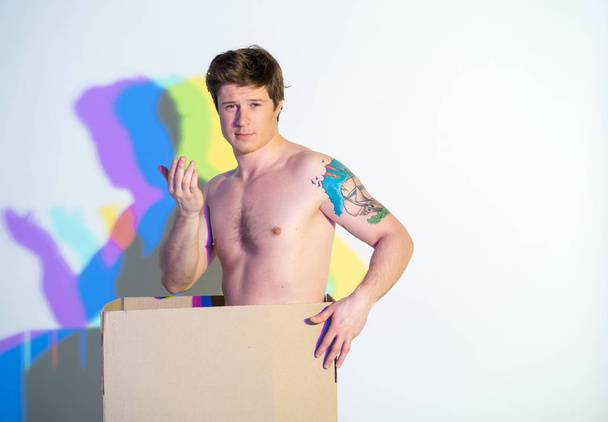 Smiling naked male gesticulating hand in box - Foto, Imagem