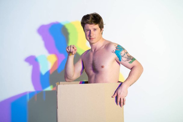 Cheerful nude man standing in carton - Zdjęcie, obraz