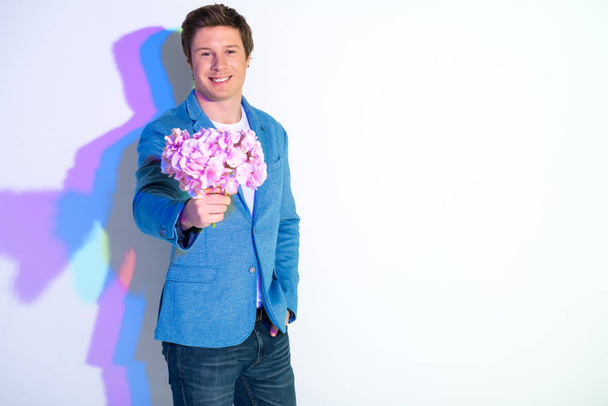 Beaming man keeping bouquet of flowers - Photo, Image