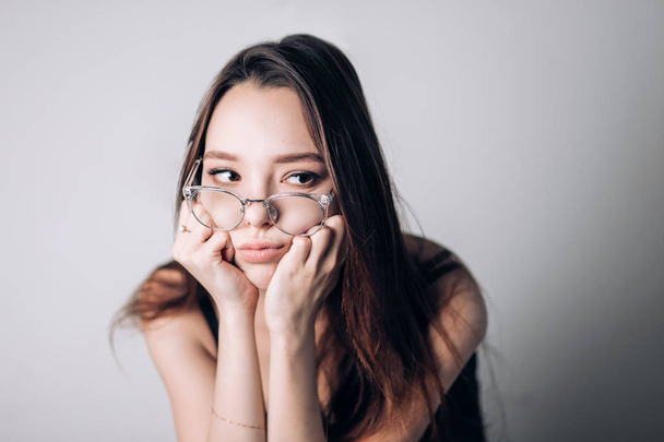 Unhappy woman in glasses looking to the side - Фото, изображение