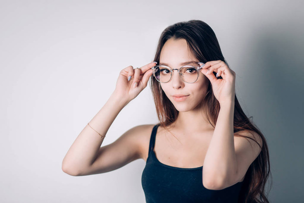 Portrait of a young Girl in glasses, a woman looking at the camera - Foto, afbeelding
