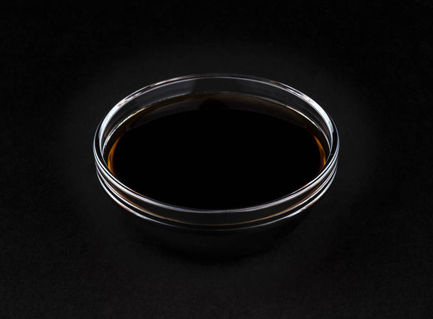 Soy sauce on black background - Foto, afbeelding