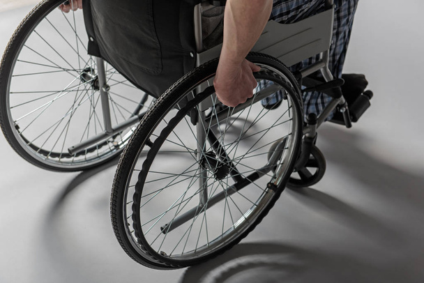 Homme tenant les bras sur des roues de fauteuil
 - Photo, image