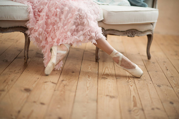 Ballerina zit, benen in pointe schoenen close-up - Foto, afbeelding