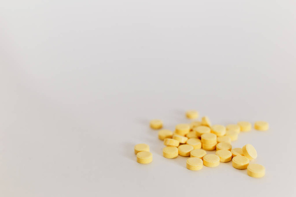 πολλά μικρά κίτρινα χάπια σε άσπρο φόντο. ιατρική - Φωτογραφία, εικόνα