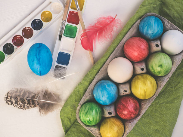 Painted easter eggs on a white, wooden table - Фото, зображення