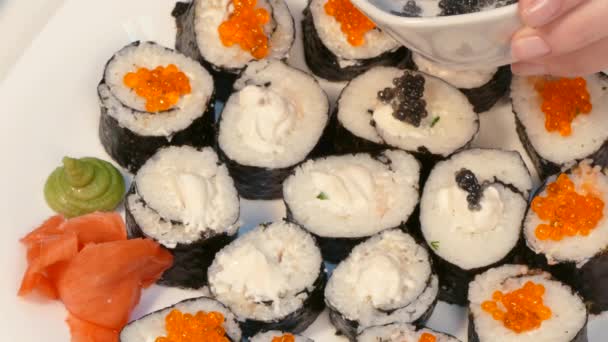 Zdobí válce sushi s černým kaviárem - Záběry, video